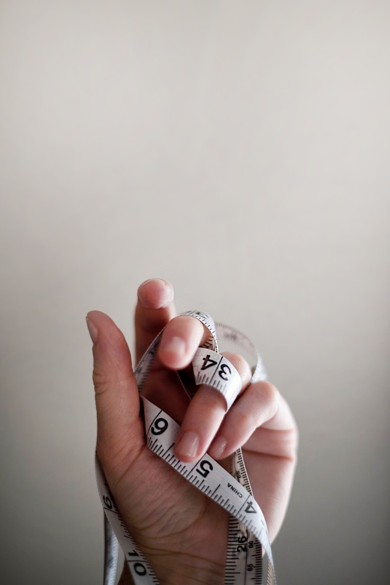 Intermittent fasting Weight watchers Keto diet Weight loss fast Weight loss pills Calorie deficit How to lose weight Nutrition Metabolism Low carb diet person's left hand wrapped by tape measure
